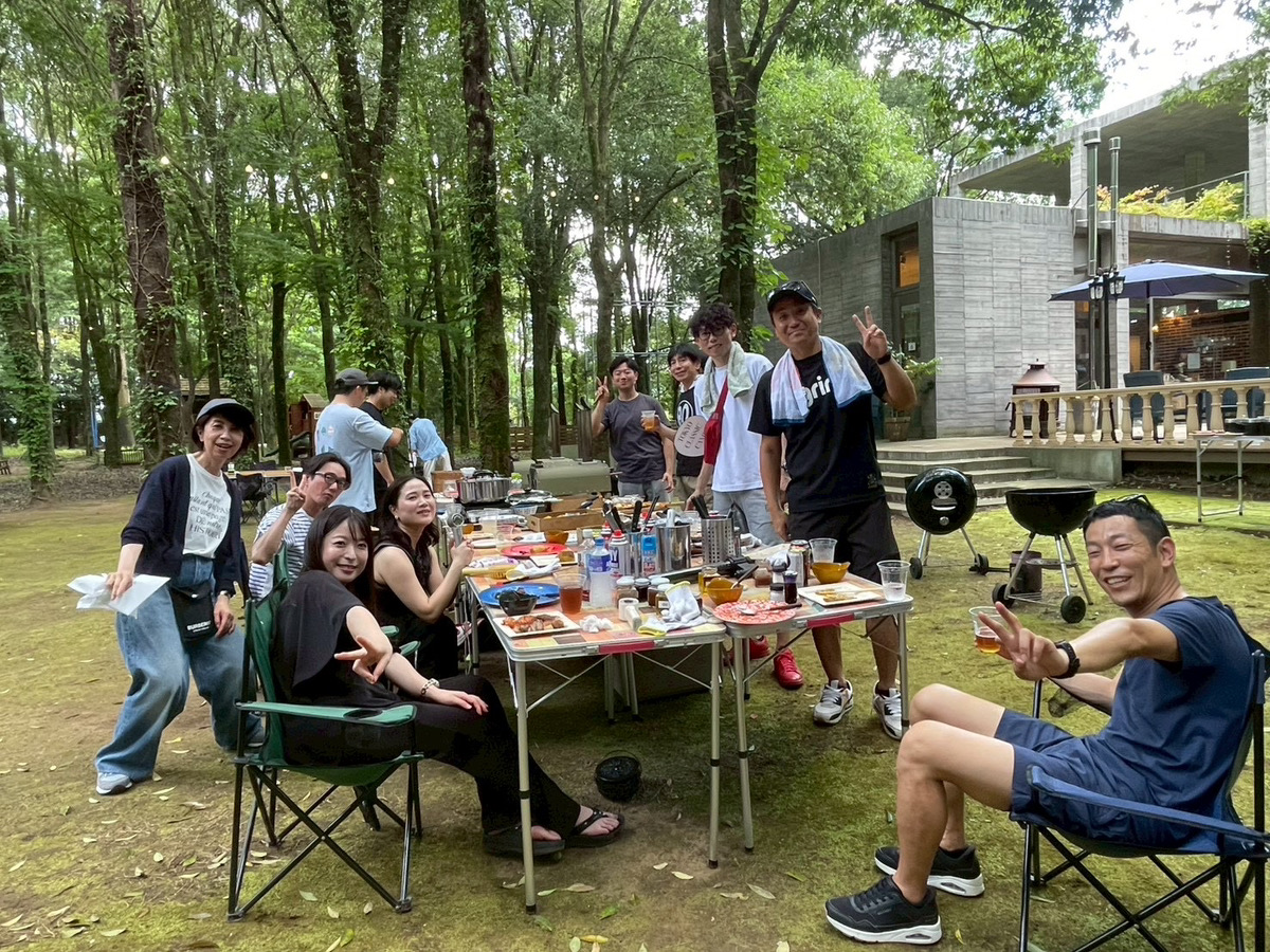 緑に囲まれた会場でBBQを楽しむ社員の様子