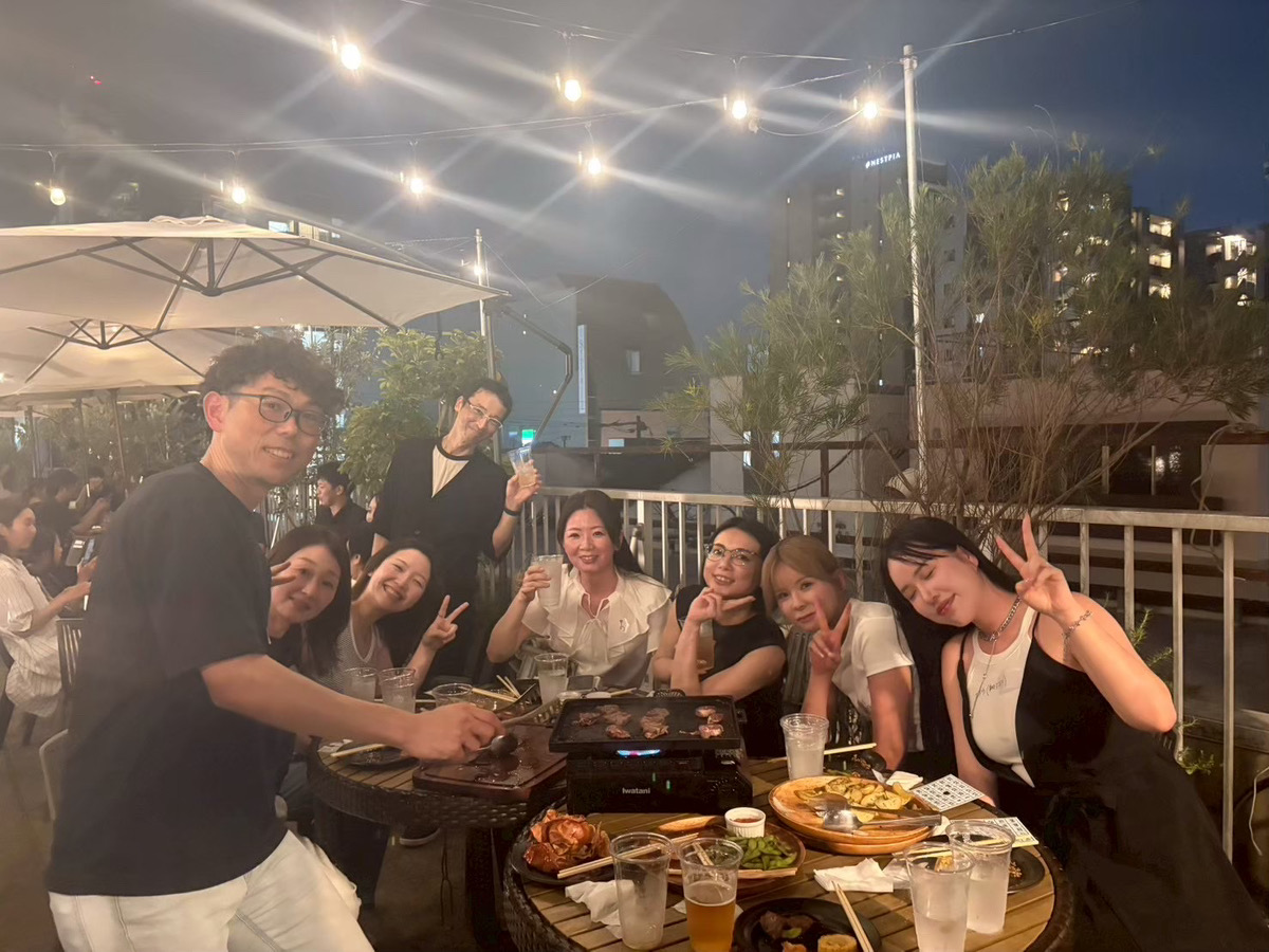 夜のBBQで食卓を囲む社員の集合写真